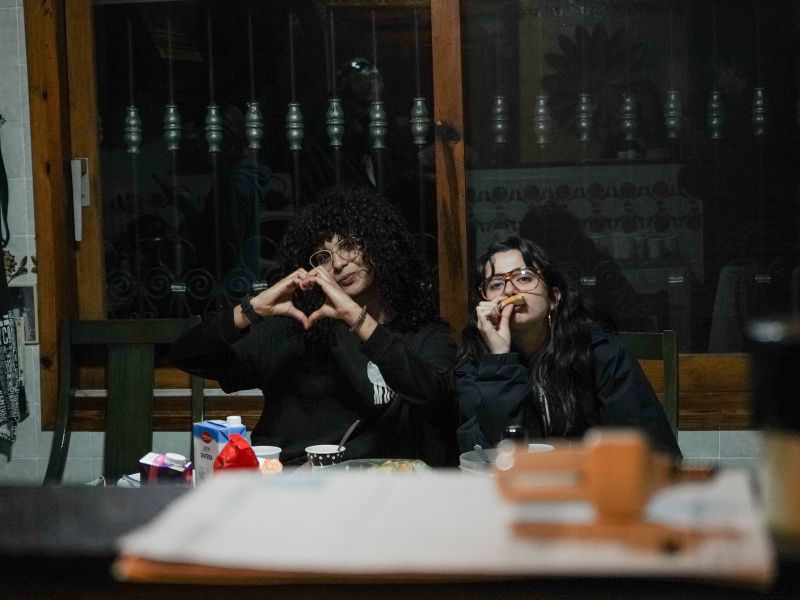 Imagen: Lara haciendo un corazón y Claudia comiendo.